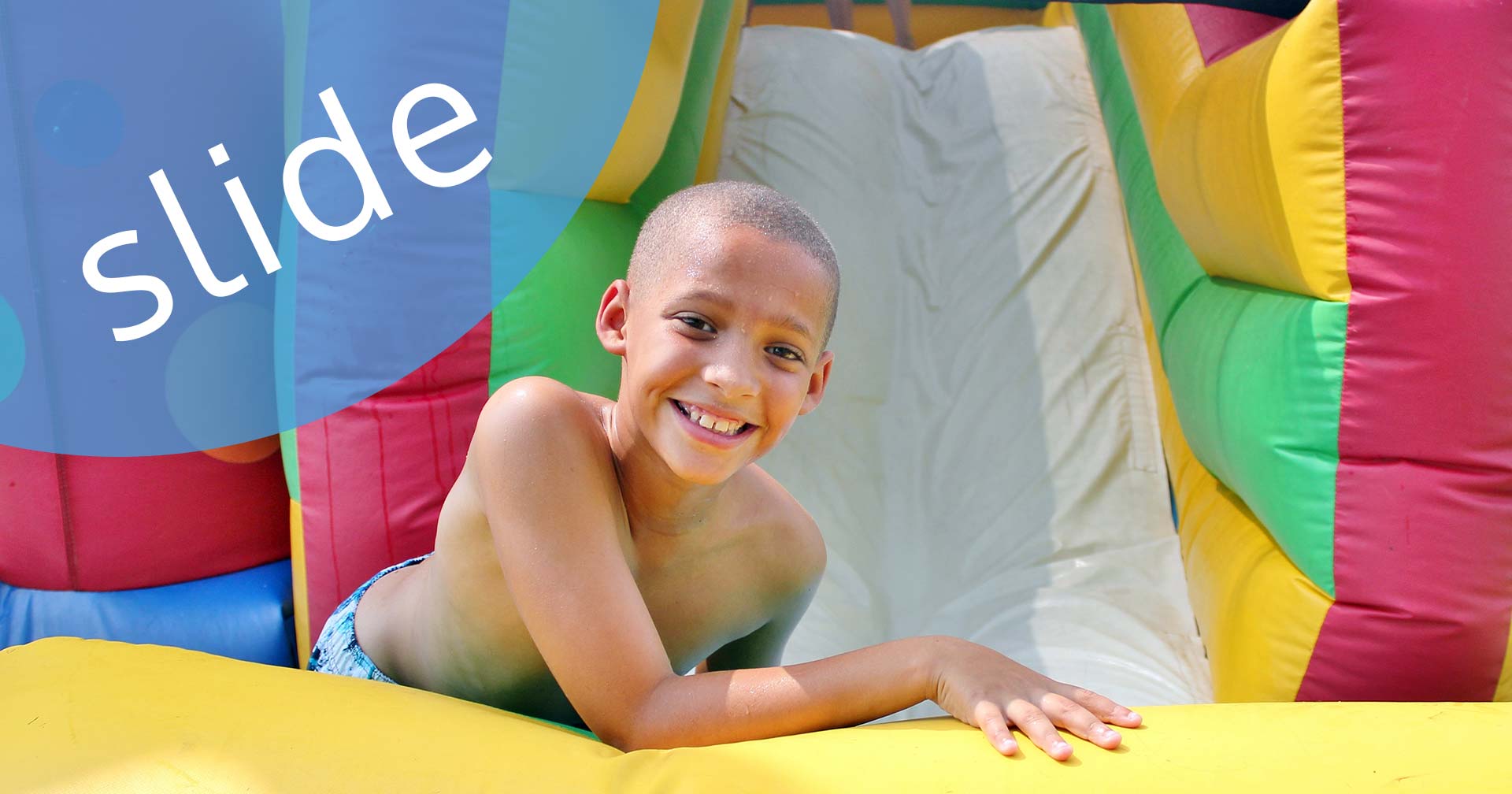 happy boy on inflatable slide